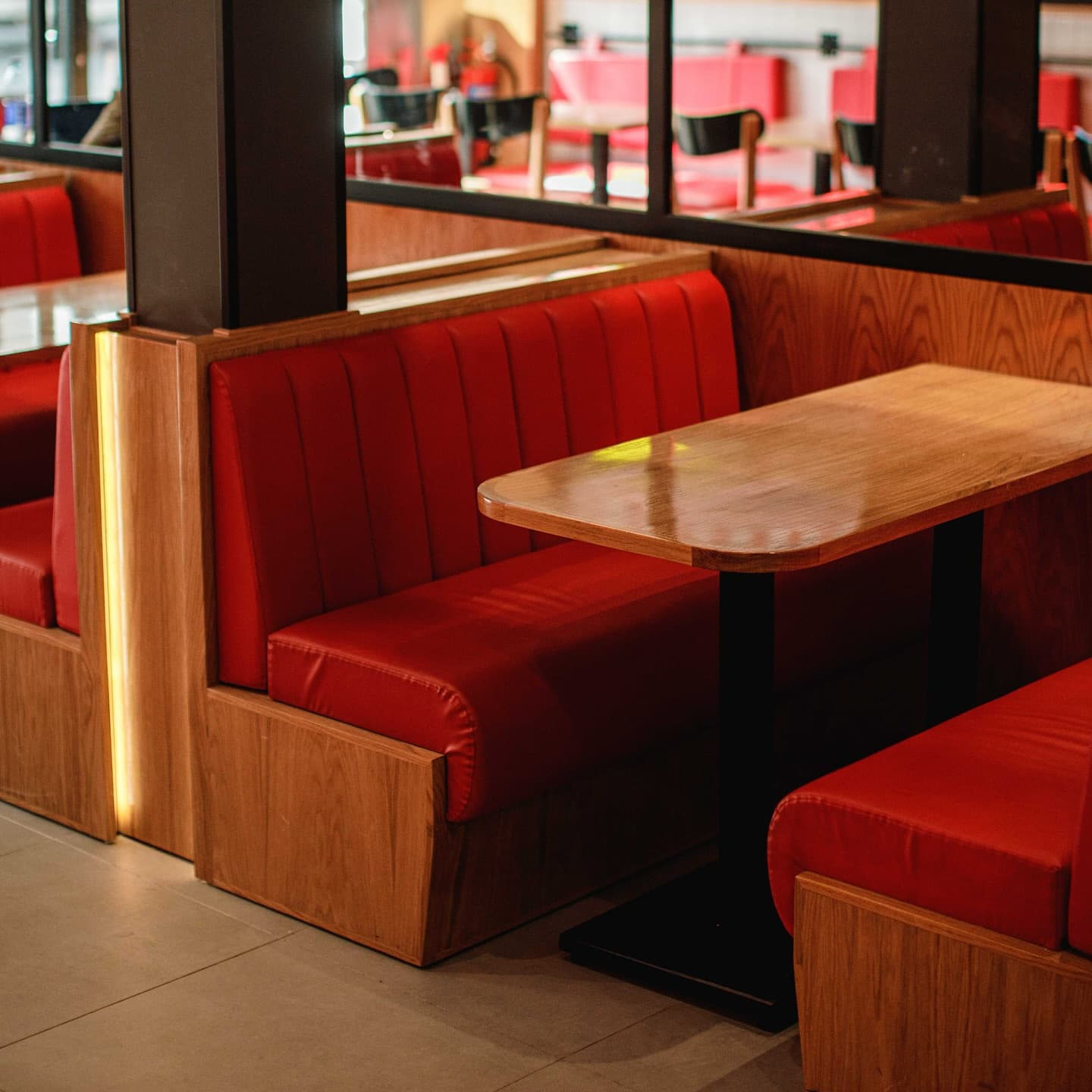 Red leather booth seating and warm wooden tables