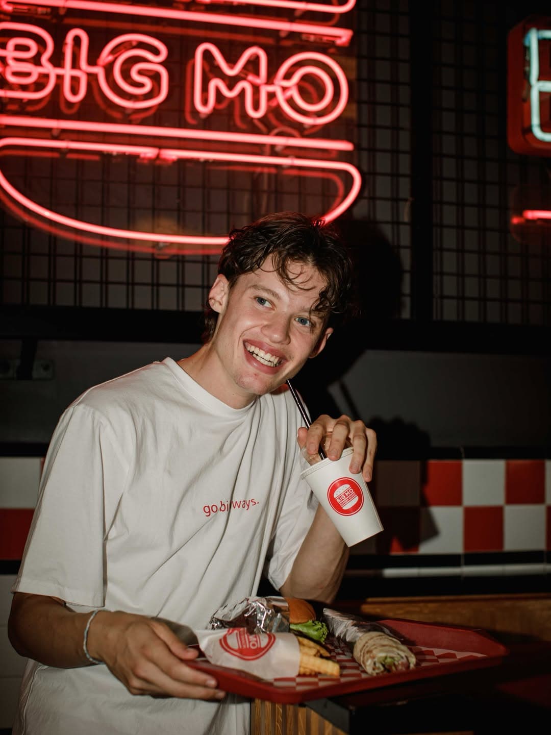 A guest enjoying a burger and drink inside BIG MO